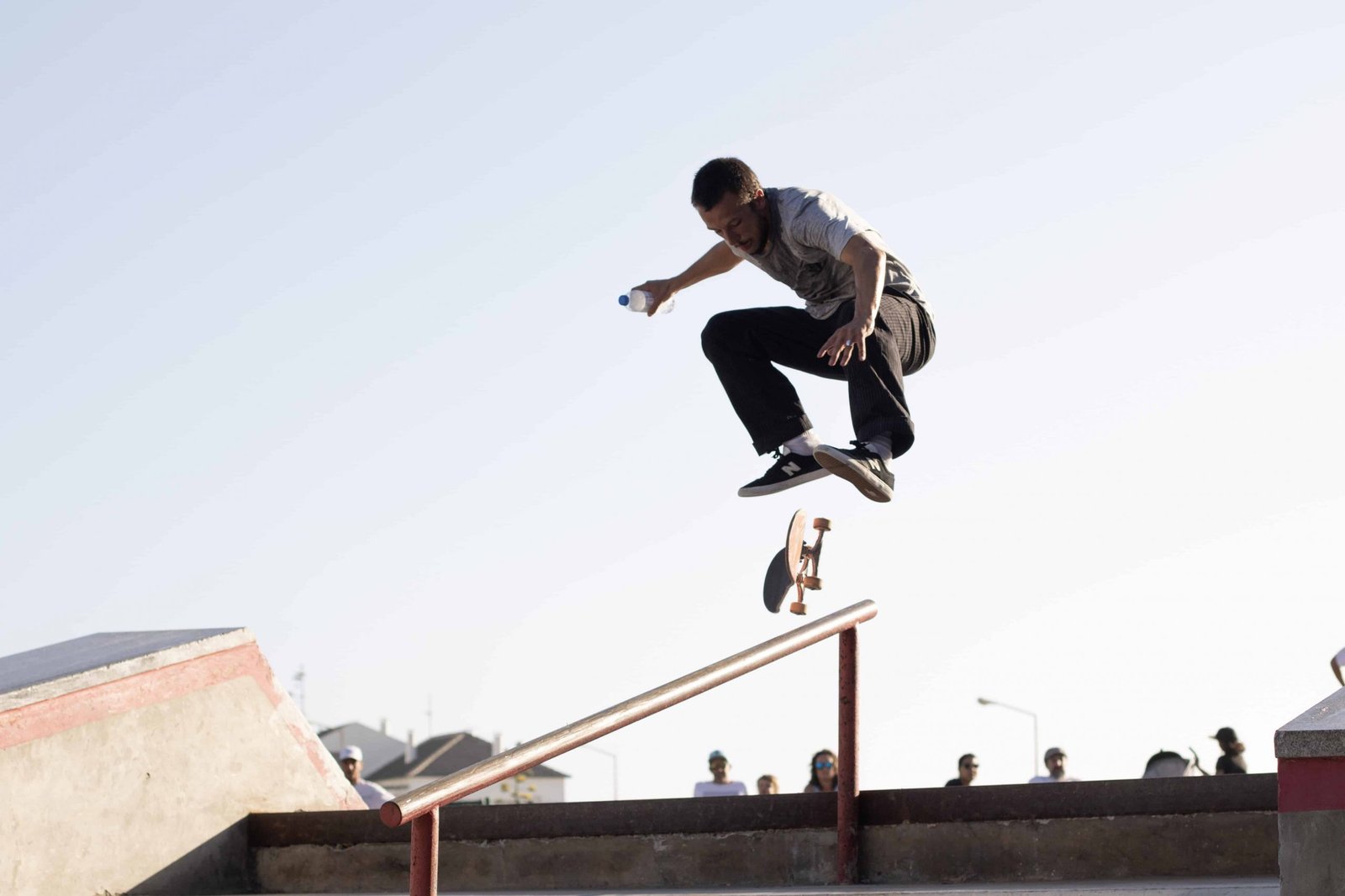 4 Spots In Cairo That Will Make You Fall In Love With Skating man wearing white t shirt performing skateboard tricks on rail under blue sky stockpack pexels scaled