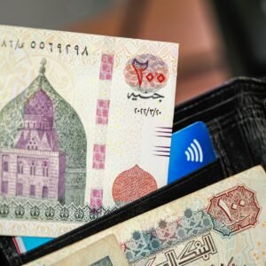 A person holding a wallet with a bank note sticking out of it