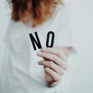 How to Set Boundaries Without Feeling Guilty Close-up of a person holding a "No" sign, symbolizing rejection or disagreement.