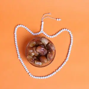 a beaded necklace with beads and nuts on an orange background